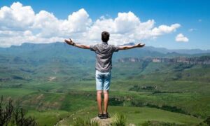 Man with arms outstretched to mountains